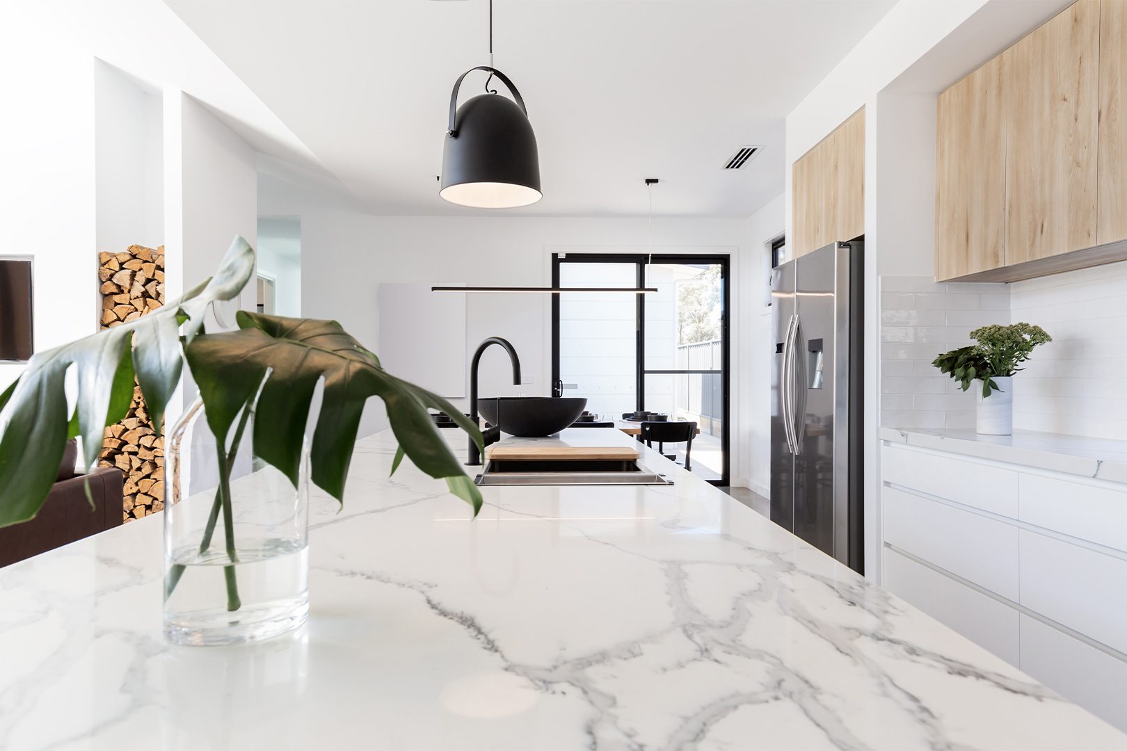 Kitchen marble bench close up with black hanging pendant and vase