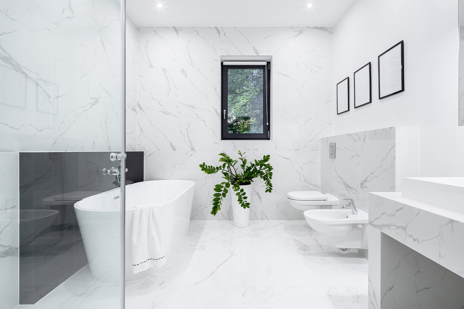 Luxury white bathroom with big bathtub and marble style tiles